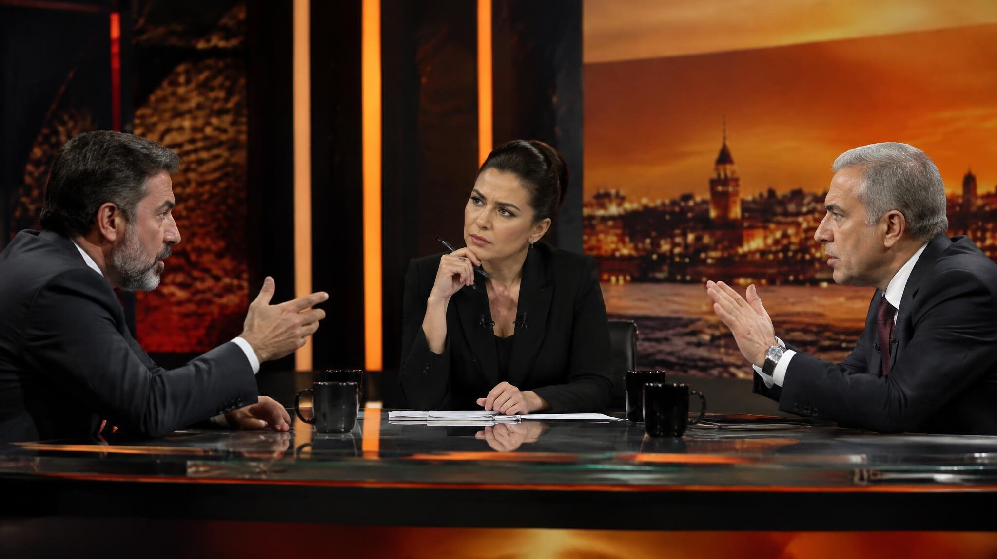 Two TV guests in a tense discussion moderated by host